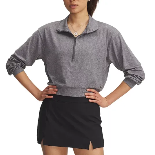 A person wearing a gray long-sleeve, half-zip pullover top and a black skirt with a side slit.