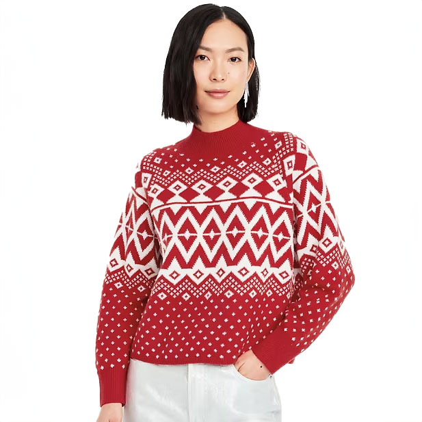 A model is wearing a red and white Fair Isle patterned sweater with a crew neck and long sleeves.
