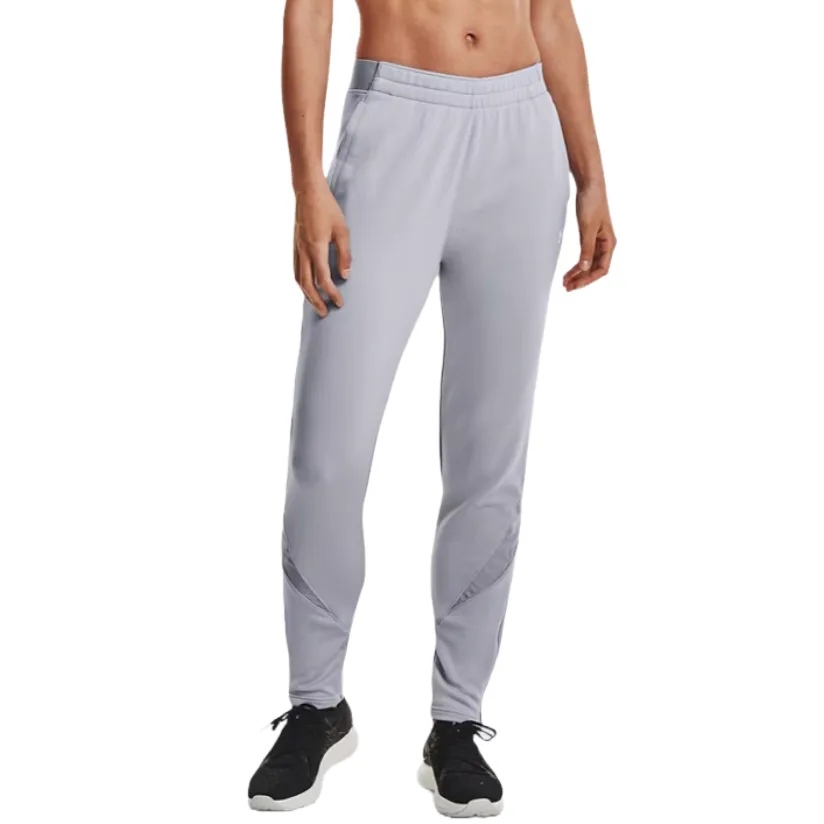 Light gray athletic pants with an elastic waistband and zippered pockets, featuring tapered legs and subtle detailing at the knees. Paired with black athletic shoes.