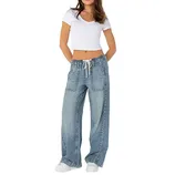 A woman wearing a white cropped T-shirt and loose-fitting drawstring denim pants with front pockets, paired with white sneakers.