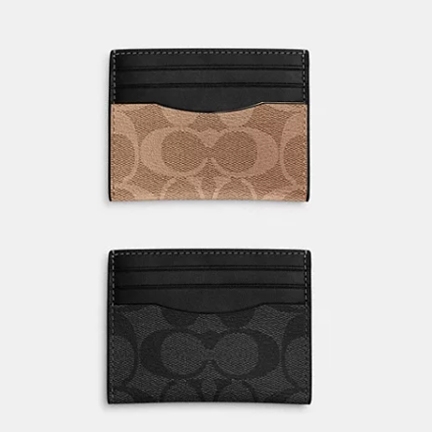 Two Coach card cases in black, one with a beige logo pattern and the other with a gray logo pattern.