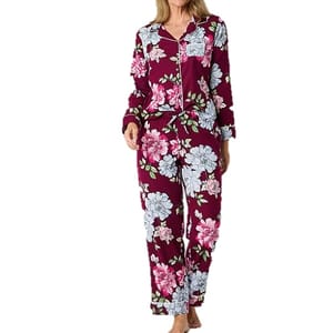 A two-piece Liz Claiborne pajama set featuring a floral pattern with a mix of white and pink flowers on a maroon background, finished with contrasting piping trim.