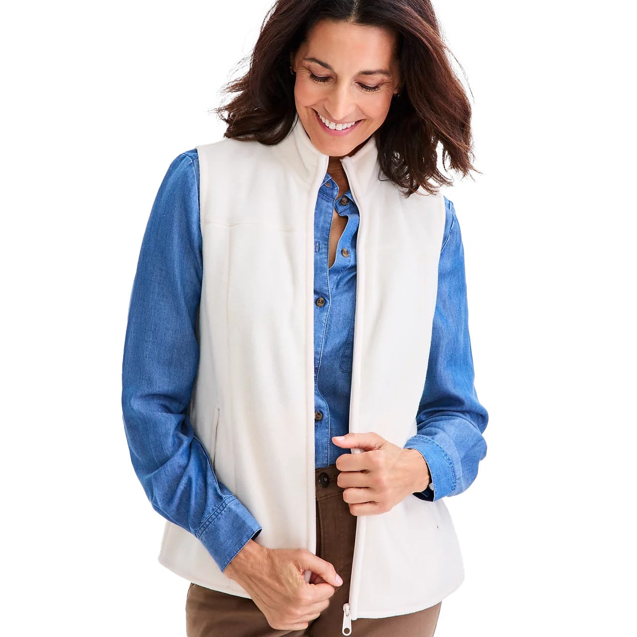 White zip-up fleece vest over a blue denim button-up shirt paired with brown pants.