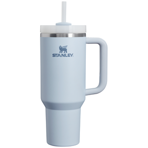The Stanley Quencher H2.0 Tumbler in light blue features a handle and a wide straw lid. It has a large capacity of 40 ounces and includes a logo with a winged animal design.