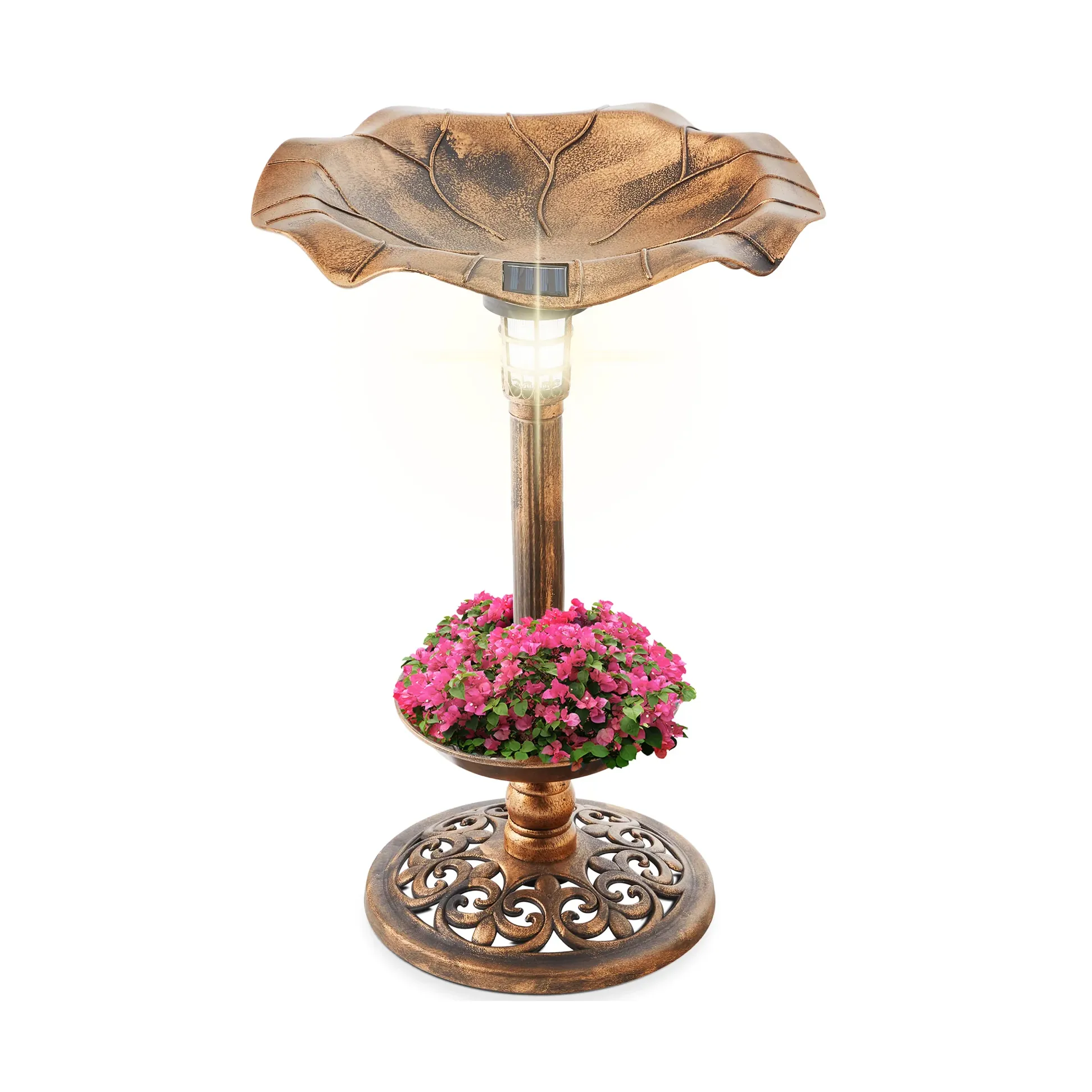 A bronze-colored birdbath with a solar light on top, featuring a design resembling a leaf. It includes a lower section filled with pink flowers and a decorative base.