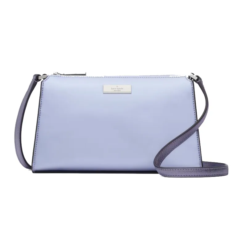 A light blue Kate Spade Kenzie Mini Crossbody bag with a long, adjustable strap, and the brand's logo on a metallic plate.