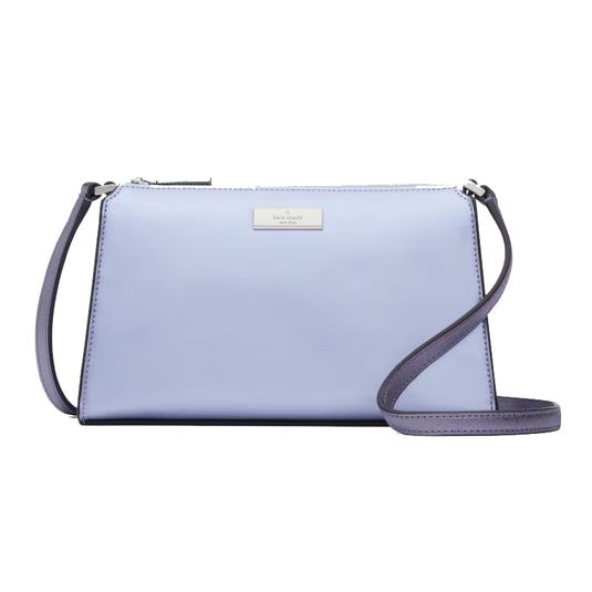A light blue Kate Spade Kenzie Mini Crossbody bag with a long, adjustable strap, and the brand's logo on a metallic plate.