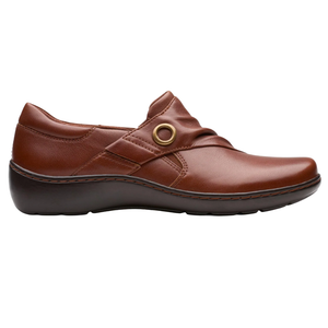 Brown leather slip-on shoe with a decorative strap and brass ring accent, featuring a cushioned sole for comfort.