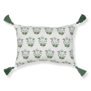 Rectangular throw pillow with a floral pattern and green tassels on each corner.