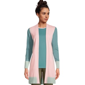 A woman wearing a pastel pink cardigan over a teal top with olive green trousers.