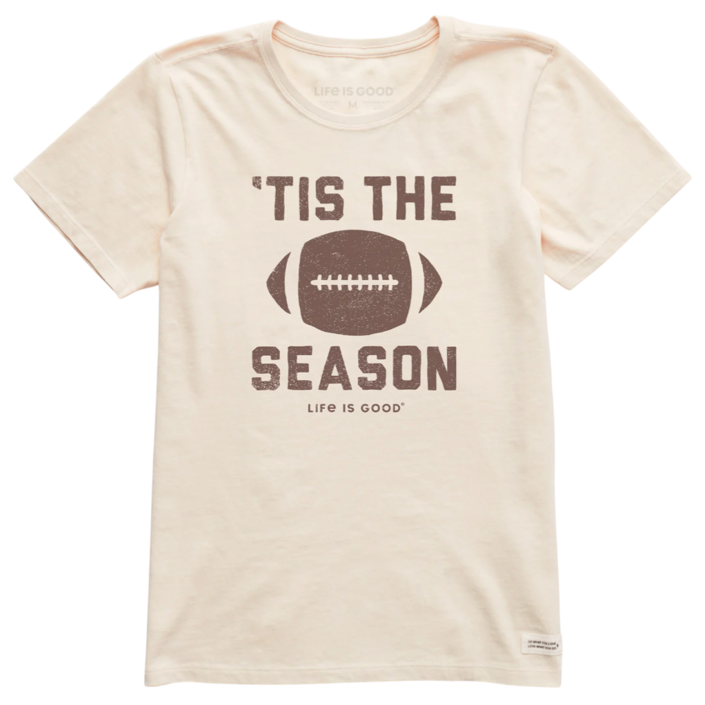 Off-white T-shirt with the text \“'Tis the Season\“ and a football graphic. The phrase \“Life is Good\“ is printed below the design.
