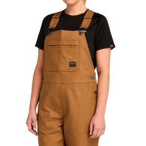Brown cotton bib overalls with a black t-shirt underneath, featuring a front pocket and side buttons.