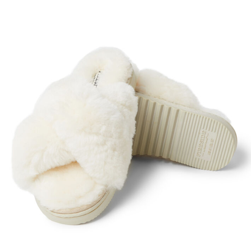 Cream-colored slippers with fluffy faux fur cross-band straps and a thick, ribbed sole for traction.