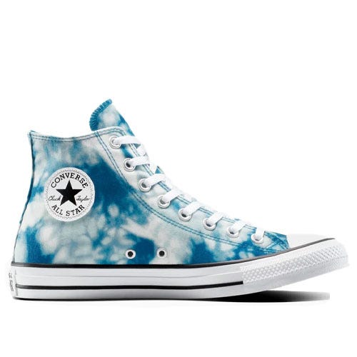 A Converse Chuck Taylor All Star high-top sneaker with a blue tie-dye design, featuring white laces and a rubber sole with the classic Converse logo patch on the side.