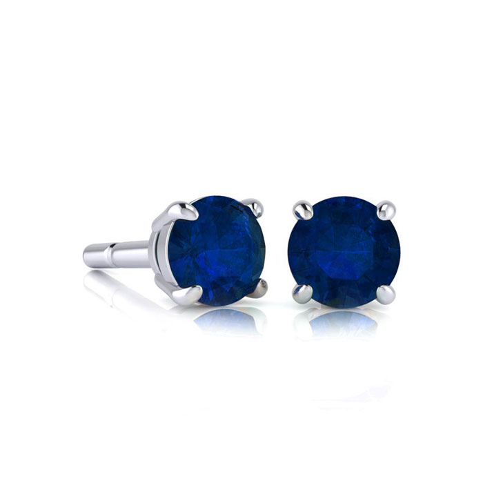 A pair of 1.5-carat blue gemstone stud earrings set in gold, with each gem secured by four prongs, showcasing a deep blue hue.