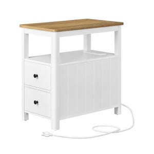 A compact white side table with two drawers, a natural wood top, and an integrated charging station. It features a cable and plug for easy access to power.
