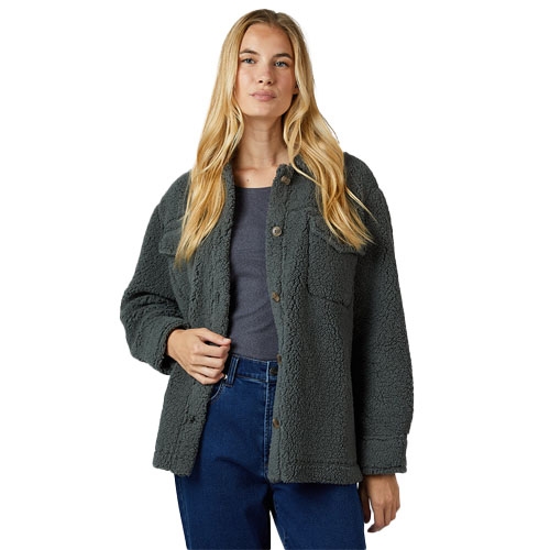 A woman is wearing a dark green sherpa fleece jacket over a gray top and blue jeans.