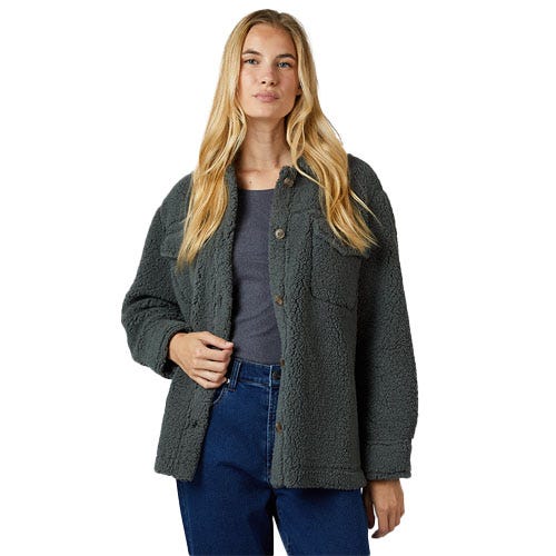 A woman is wearing a dark green sherpa fleece jacket over a gray top and blue jeans.
