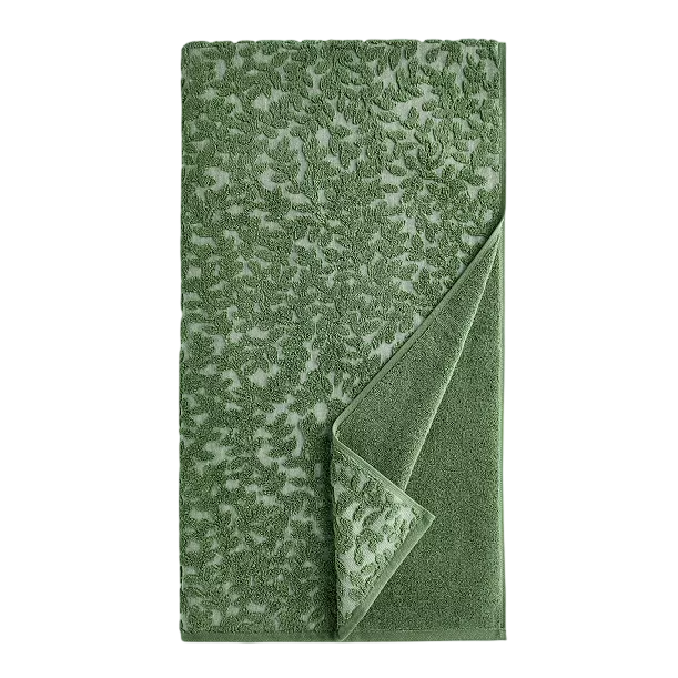 Green jacquard towel with a leaf pattern, featuring a folded corner to reveal a solid-colored underside.
