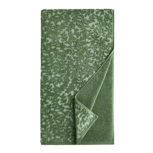 Green jacquard towel with a leaf pattern, featuring a folded corner to reveal a solid-colored underside.