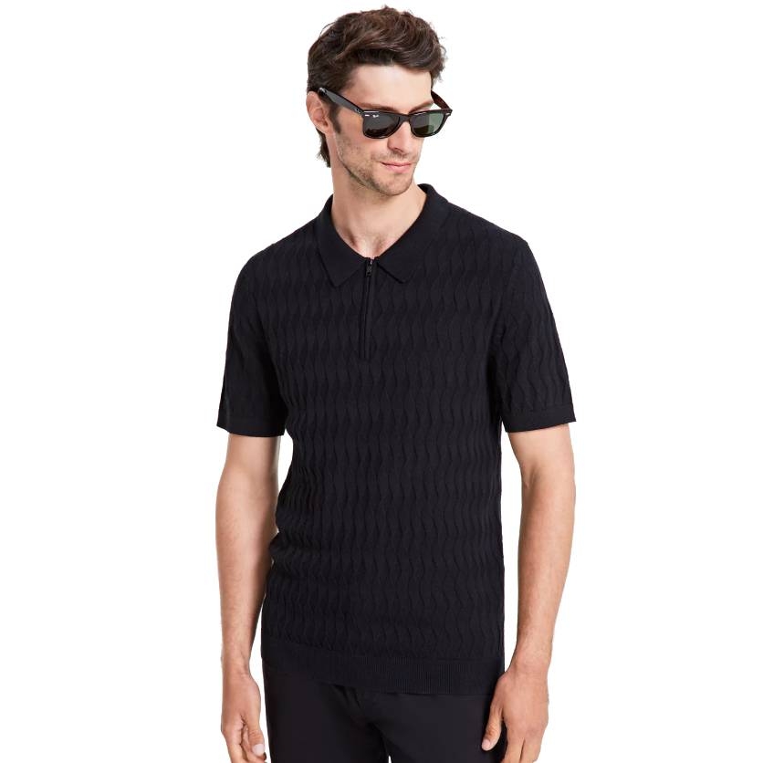 A man is wearing a black textured short-sleeve polo sweater with a zip-up collar, paired with sunglasses.