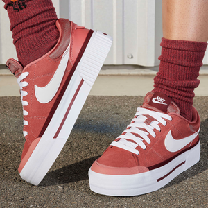 A pair of red and white sneakers with a high sole profile, alongside matching red socks.