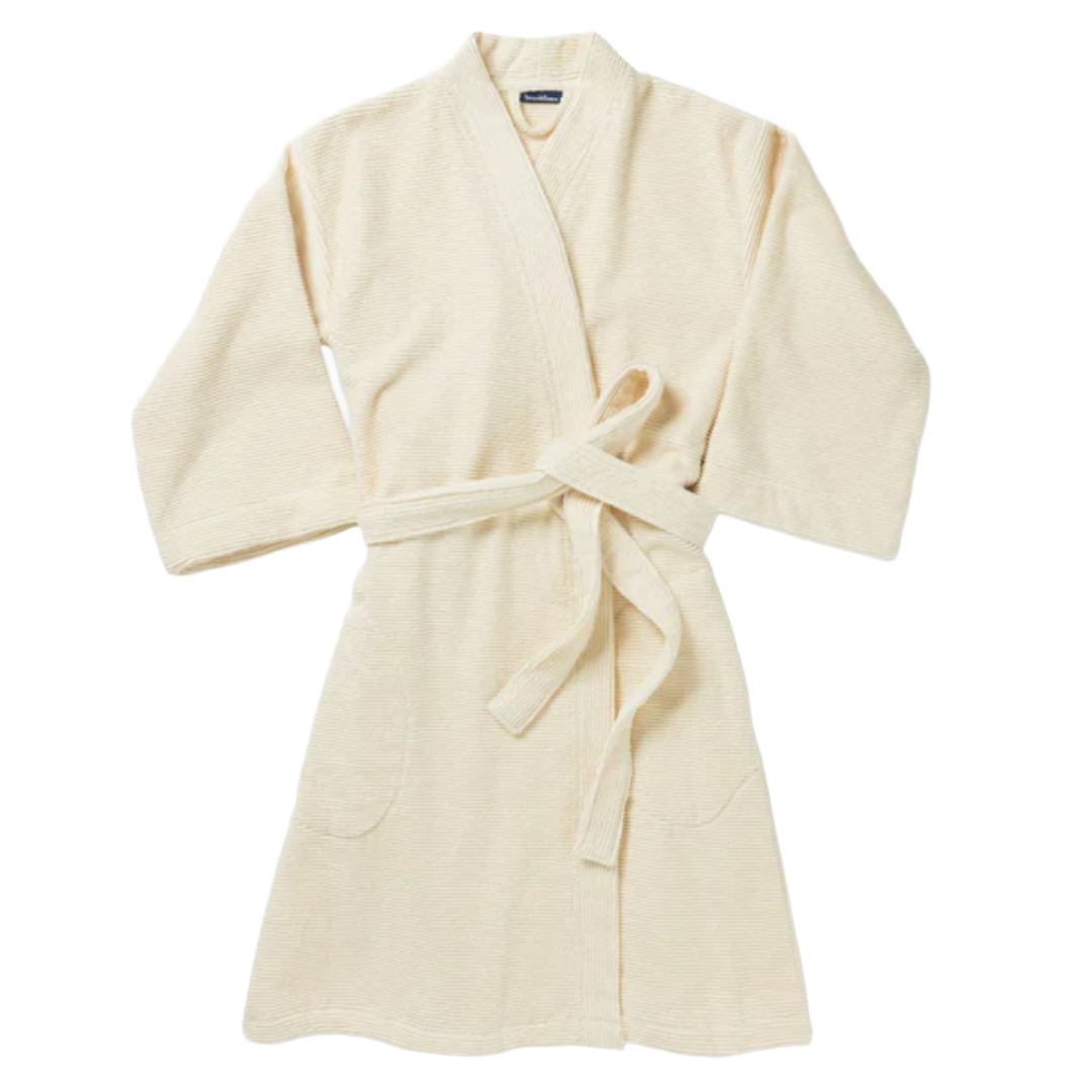 A beige bathrobe with a belt and two front pockets.