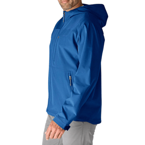 A person is wearing a blue hooded jacket with zippered pockets, paired with light gray pants against a white background.