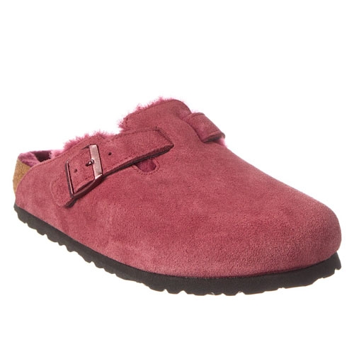 This is a pair of red suede clogs featuring a strap with a buckle across the top and a dark, ribbed sole. The interior is lined with a light-colored plush material.