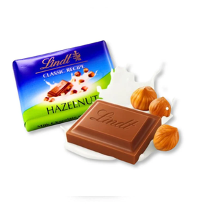 Lindt Classic Recipe Hazelnut Milk Chocolate, featuring a bar with milk and whole hazelnuts, wrapped in a blue and green package with an illustration of chocolate and nuts.