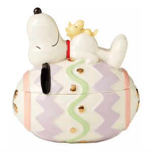 Lenox Snoopy Easter Candy Dish features Snoopy and Woodstock resting on a pastel and gold-dotted Easter egg. The dish doubles as a decorative piece and functional candy holder.