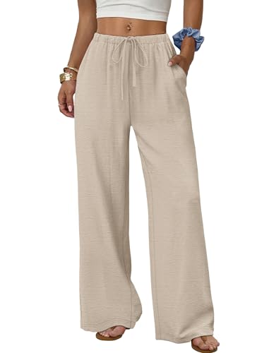 A person wears loose-fitting beige wide-leg pants with an elastic waistband and drawstring, paired with a white crop top and sandals.