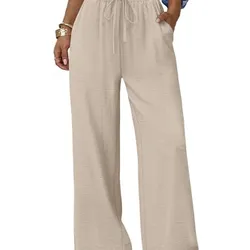 A person wears loose-fitting beige wide-leg pants with an elastic waistband and drawstring, paired with a white crop top and sandals.