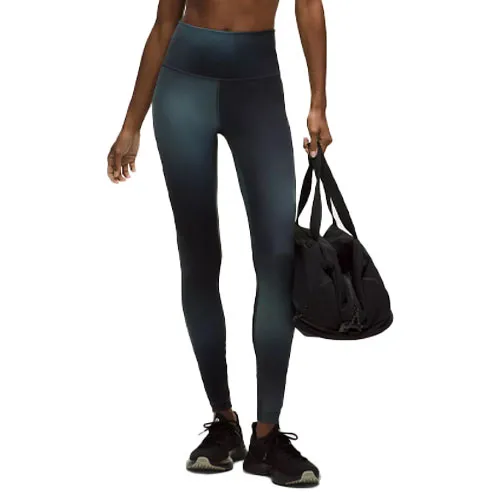 A person wears high-waisted leggings and black sneakers, carrying a black gym bag.