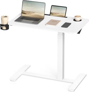 A white height-adjustable desk featuring a laptop, tablet, notebook, smartphone, coffee cup, and tumbler, providing an organized workspace with integrated cup holders.