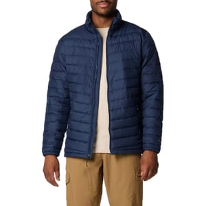 A man is wearing a navy blue, quilted insulated jacket with a full-zip front, stand-up collar, and side pockets.