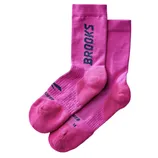 Bright pink socks with \“BROOKS\“ written vertically in bold black letters on the sides.