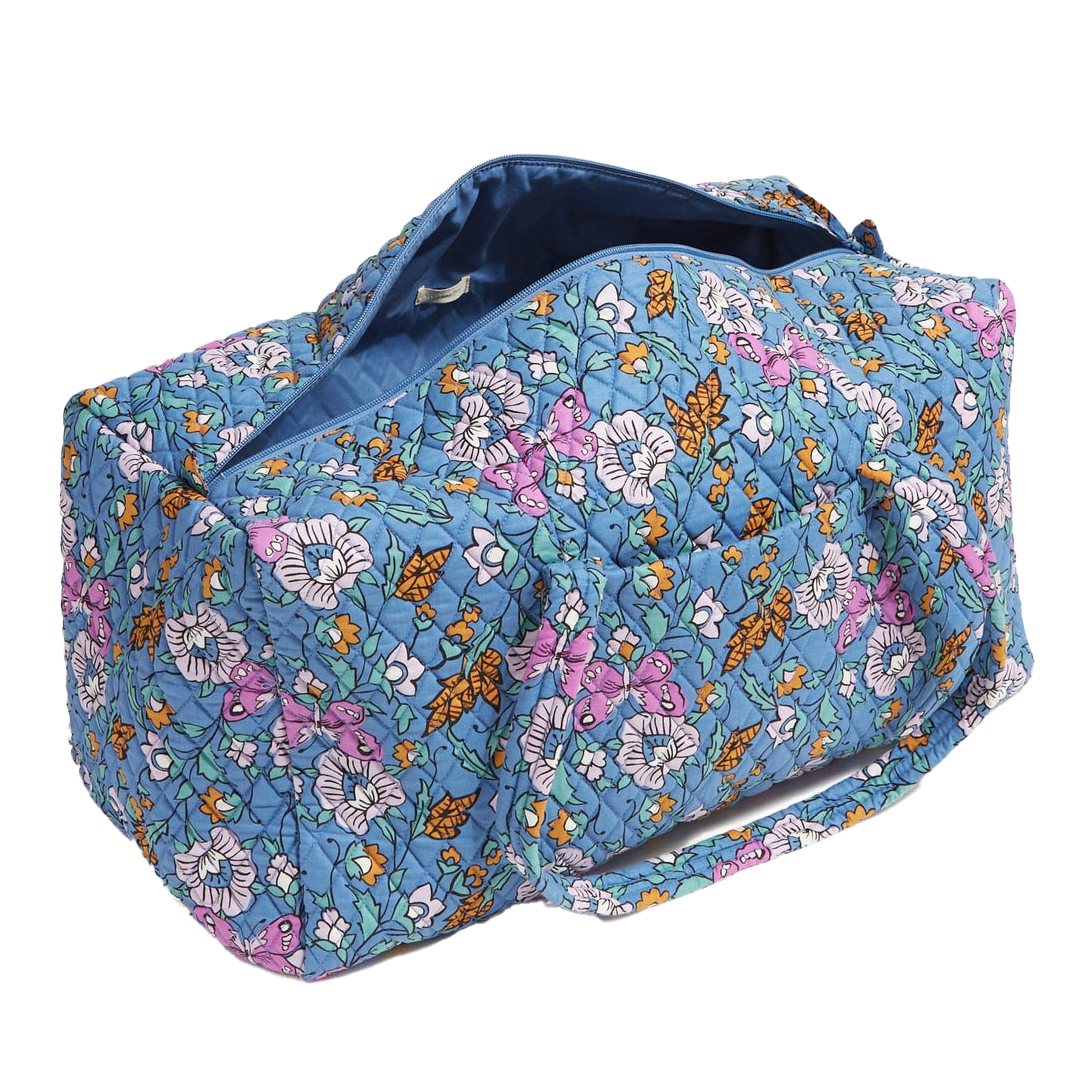 A blue floral quilted fabric duffel bag with a zipper on top, designed for travel or gym use.