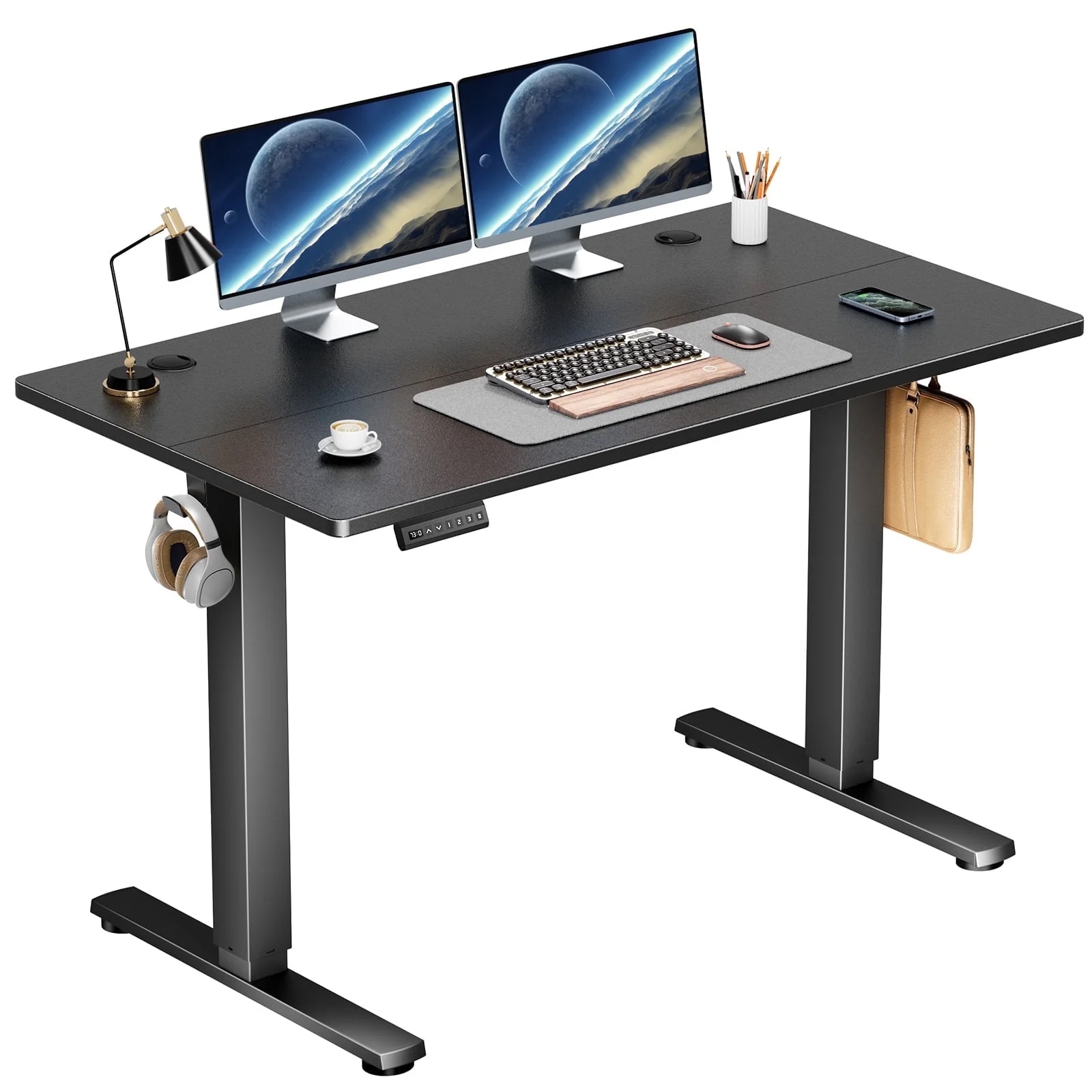 A black electric standing desk with dual monitors, a keyboard, mouse, desk lamp, headphones, a cup of coffee, pen holder, and a laptop bag. The desk features a height control panel and hooks for accessories.