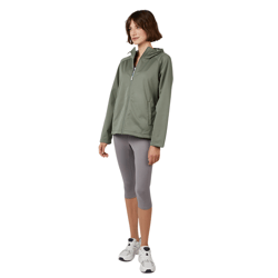 A person is wearing a sage green zip-up jacket with a hood, paired with gray capri leggings and white sneakers.