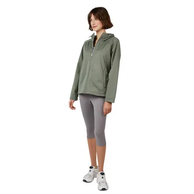 A person is wearing a sage green zip-up jacket with a hood, paired with gray capri leggings and white sneakers.