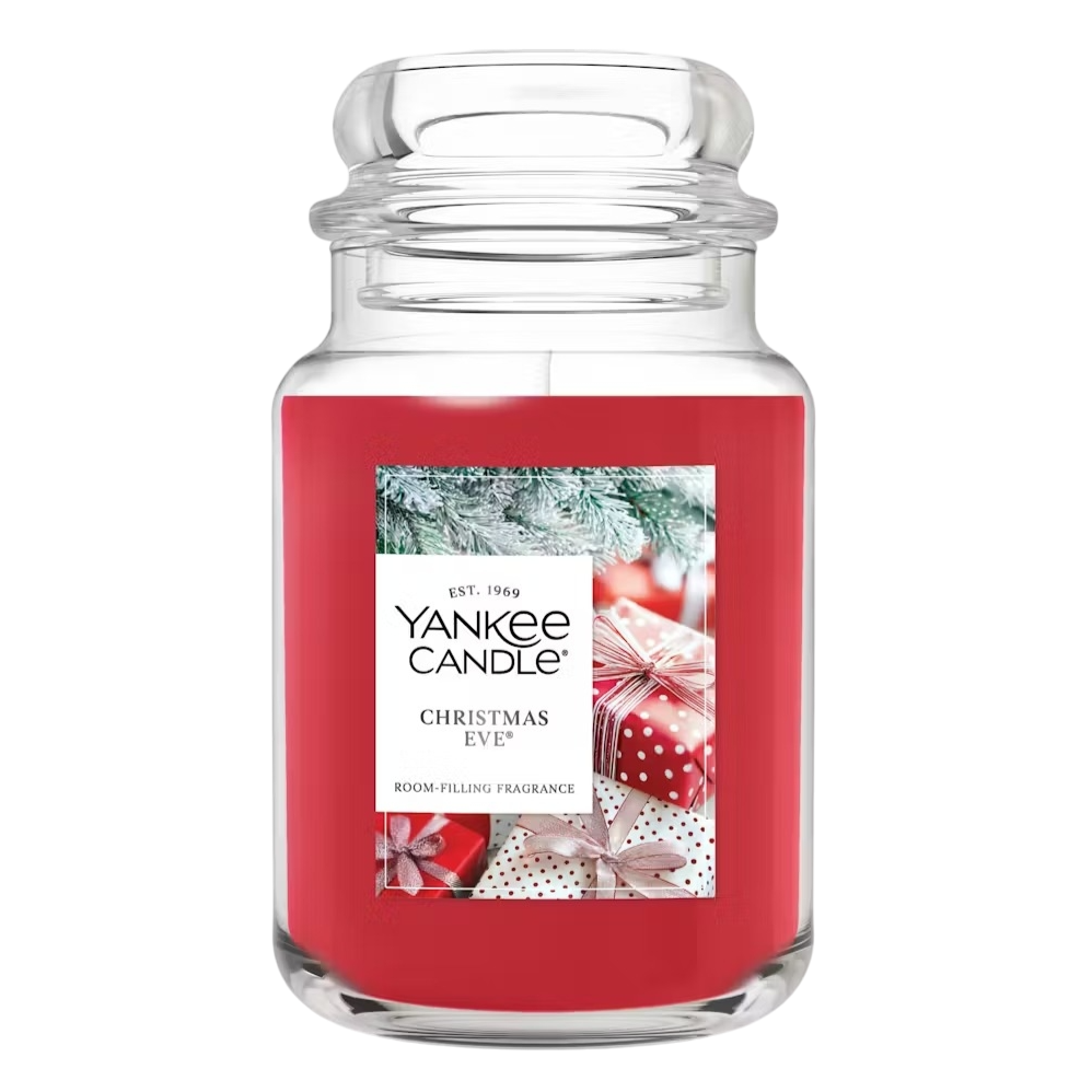Yankee Candle \“Christmas Eve\“ features a red jar with a festive design of gifts and pine branches, offering a room-filling fragrance.
