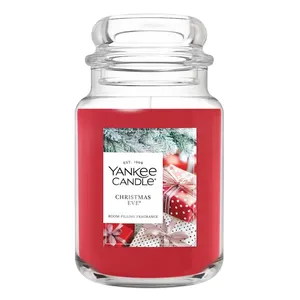 Yankee Candle \“Christmas Eve\“ features a red jar with a festive design of gifts and pine branches, offering a room-filling fragrance.