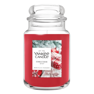 Yankee Candle \“Christmas Eve\“ features a red jar with a festive design of gifts and pine branches, offering a room-filling fragrance.