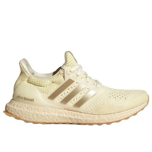 Adidas Ultra Boost shoe in a light cream colorway with a knit upper, cushioned midsole, and three stripes branding on the side.