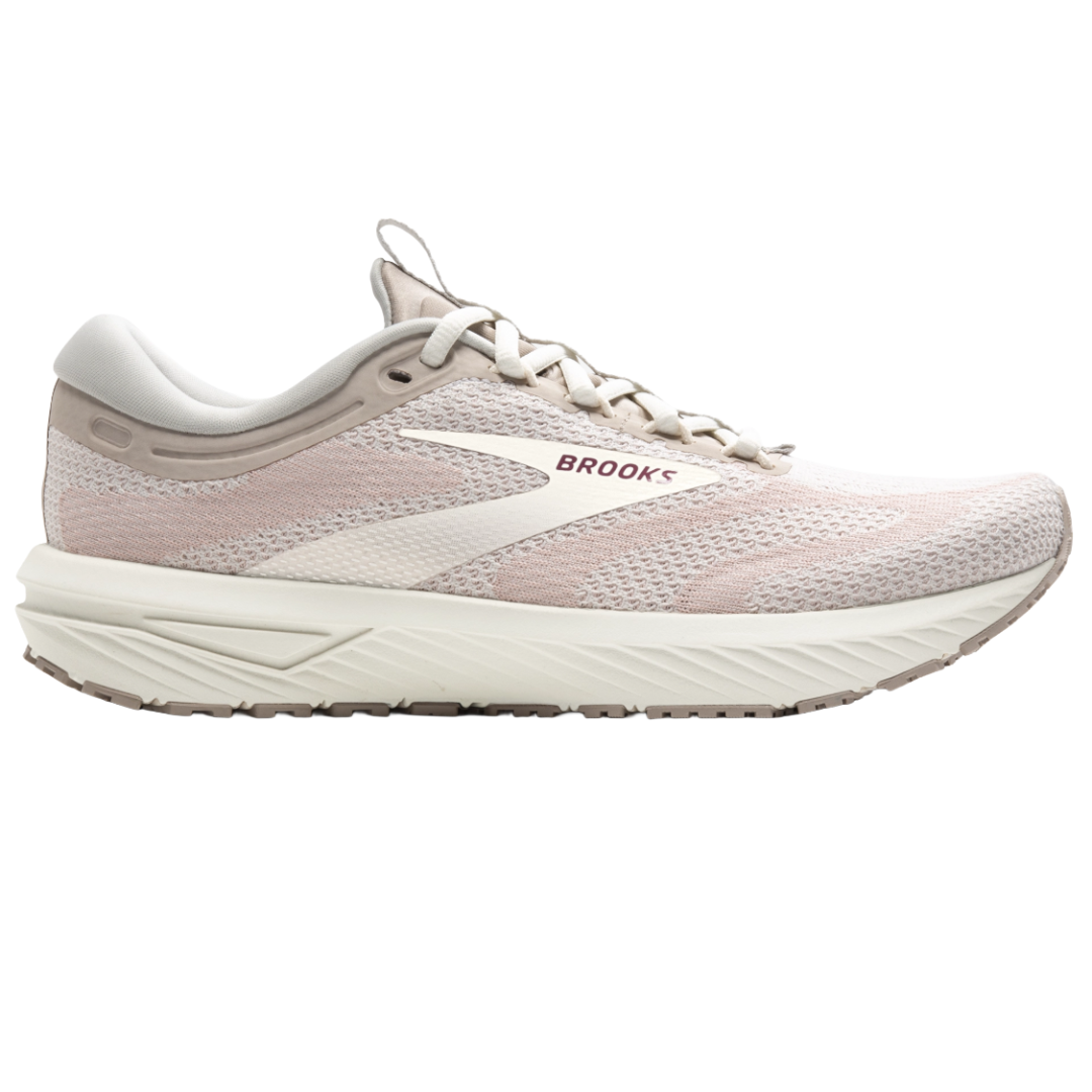 A beige and white Brooks running shoe with a breathable mesh upper and sturdy sole designed for comfort and performance.