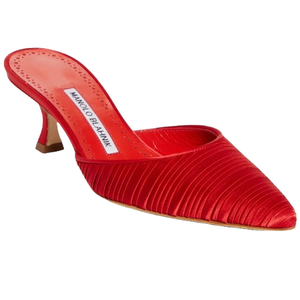 The Manolo Blahnik Carolyne Mules are red, satin-textured with a pleated design, featuring a pointed toe and a low heel. The insole displays the brand's logo.