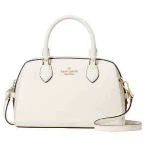 A white Kate Spade New York handbag featuring dual top handles and an adjustable shoulder strap, accented with gold-tone hardware and the brand’s logo embossed on the front.