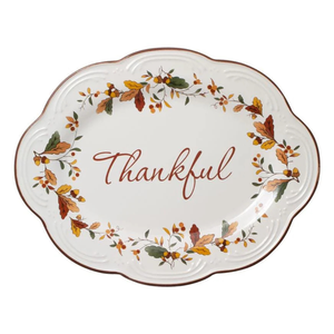 Oval ceramic platter with the word \“Thankful\“ in the center, decorated with autumn leaves and berries along the rim.