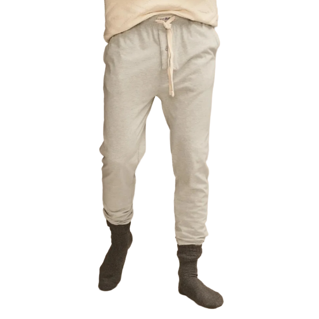 A person is wearing light gray jogger pants with a drawstring waist, paired with dark gray socks.